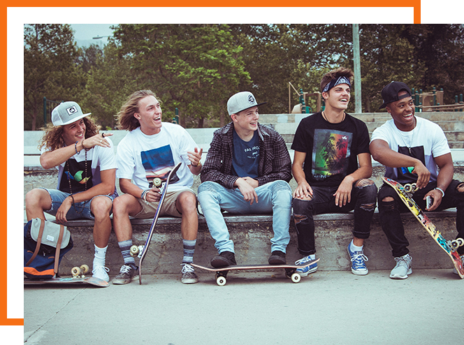 A group of young men sitting on top of a bench.