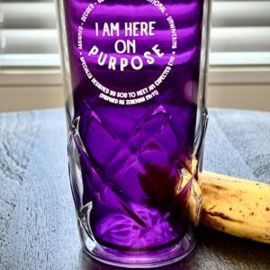A purple glass with the words " i am here on purpose ".