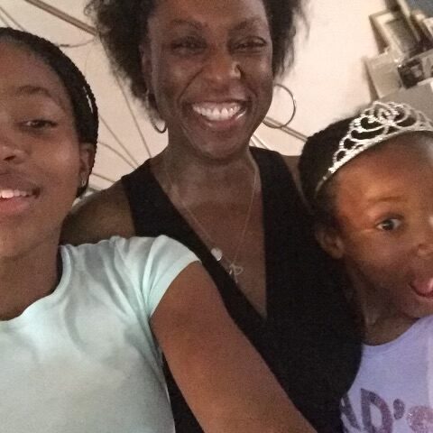 A woman and two girls are smiling for the camera.